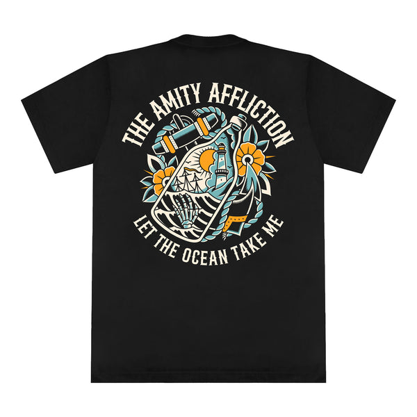 Black Comfort Colors T-shirt by The Amity Affliction, showcasing vibrant nautical, floral, and ship artwork. "The Amity Affliction" appears above and "Let the Ocean Take Me" below the central design.