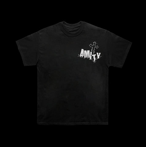 image of the front of a black tee shirt. tee has small white print on right chest of a cross and the word amity in a cemetery setting