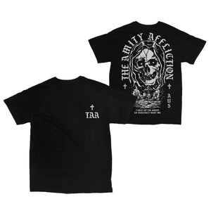 image of the front and back of a black tee shirt on a white background, front of the tee is on the left and has a small right chest print in grey that has a small cross and the letters T A A. the back is on the right and has a full back print in grey of a skull face over a cementary. arched around that says the amity affliction. across the bottom says i gave up the ghost so endlessly bury me