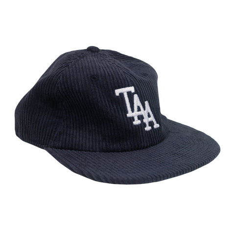 image of a dark blue corduroy hat on a white background. hat has white embroidery on the front center area of the letters T A A 