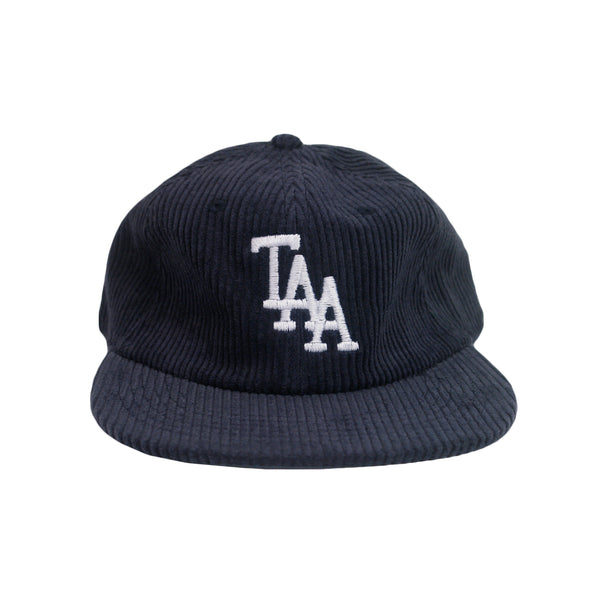 image of a dark blue corduroy hat on a white background. hat has white embroidery on the front center area of the letters T A A 